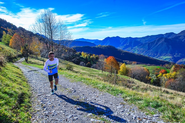 Un atleta de montaña se entrena en el camino de tierra.