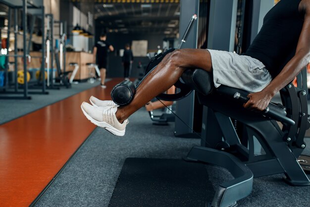 Atleta musculoso en ropa deportiva en máquina de ejercicio