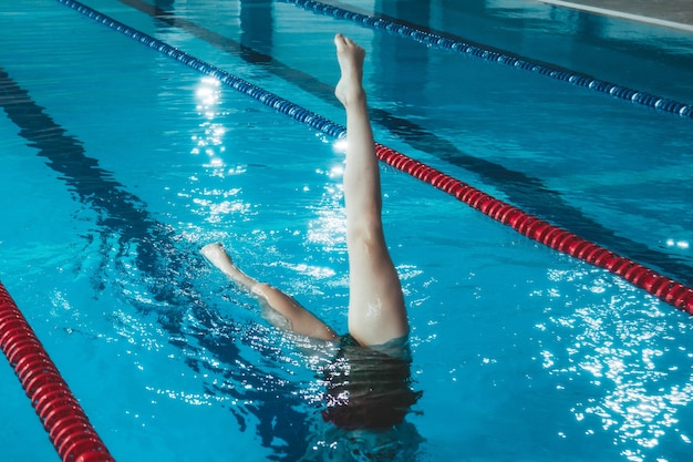 Atleta de natación sincronizada entrena solo en la piscina