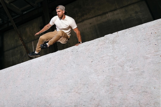 El atleta de parkour está haciendo un entrenamiento extremo en la ciudad.