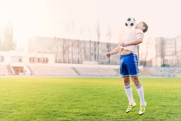 Atleta pegando bola de futebol com peito