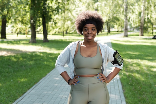 Atleta plus size feliz em pé no parque