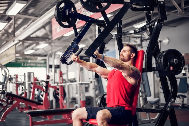 El atleta poderoso que hace ejercicios en los músculos pectorales.