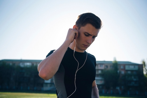 El atleta se pone los auriculares antes de correr