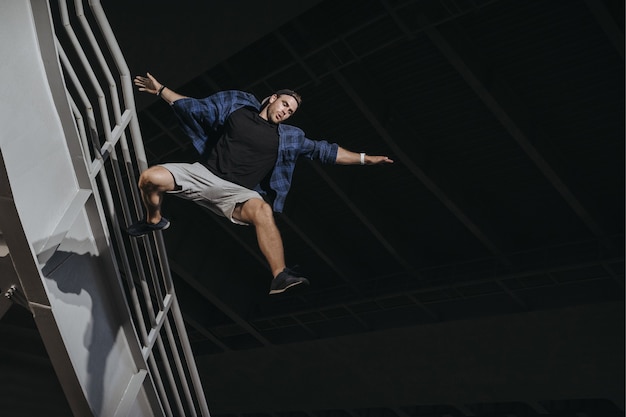 Atleta praticando freerunning fazendo um grande salto assustador. Parkour gosta de estilo de vida