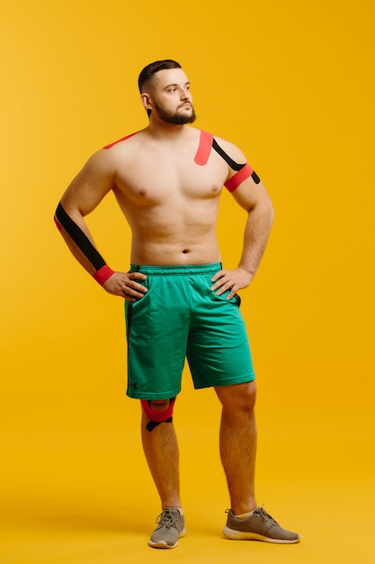 Un atleta profesional con cinta de kinesiología en brazo y hombro.