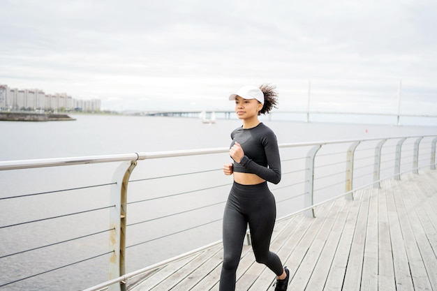 La atleta que corre hace ejercicios de fitness cardiovascular activos utiliza un reloj de fitness y un rastreador