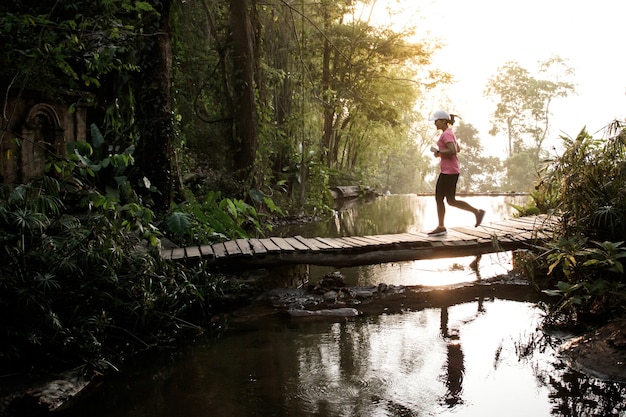 Foto atleta running da fuga que move-se através da ponte na estrada rural.