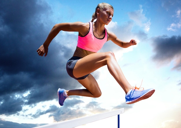 Atleta saltando sobre un obstáculo contra el cielo en segundo plano.