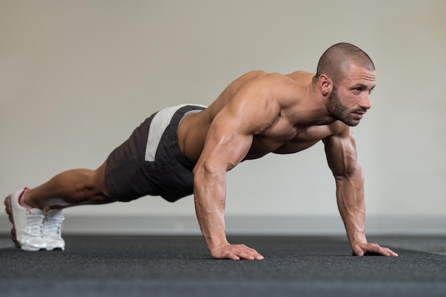 Atleta saludable haciendo flexiones como parte del entrenamiento de culturismo