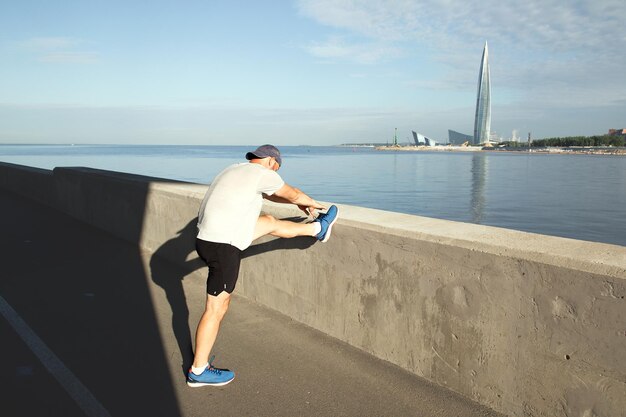 Atleta se aquecendo no aterro em frente à torre