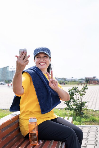 Atleta sênior sorridente fazendo selfie ao ar livre no parque