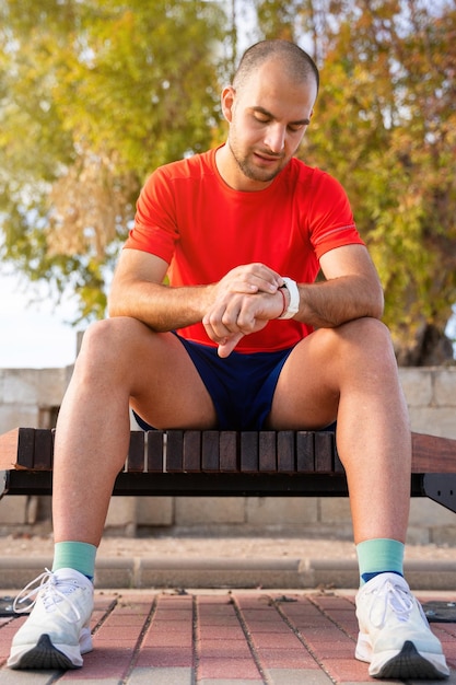 Atleta sentado usando el reloj deportivo