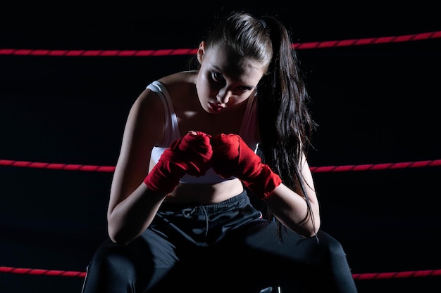 El atleta se sienta en una silla en el ring de boxeo después de perder la pelea a pesar de la preparación técnica el atleta perdió la pelea