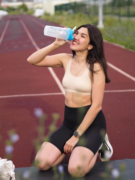 Atleta sorridente a beber água.