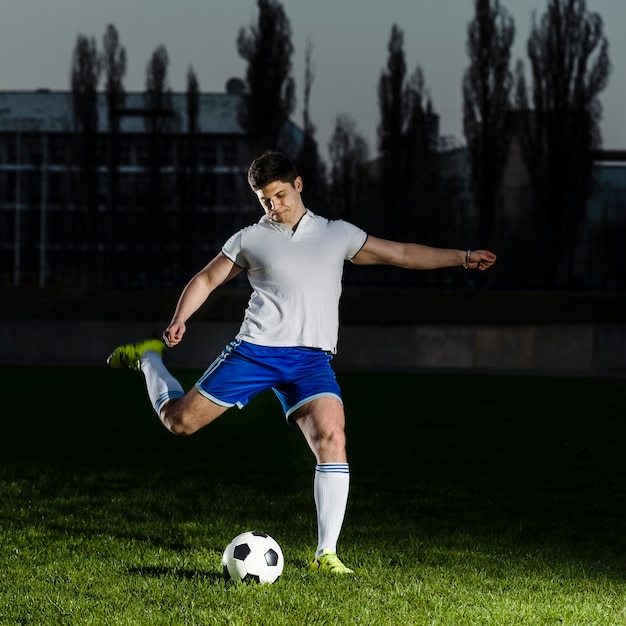 Atleta tirando el balón de fútbol