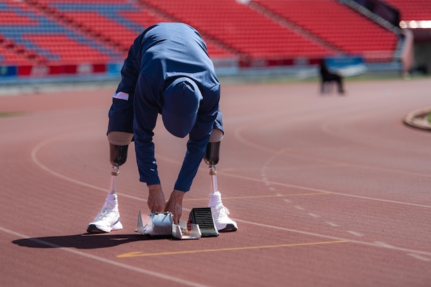 Foto atletas deficientes preparam-se em posição de partida prontos para correr na pista do estádio