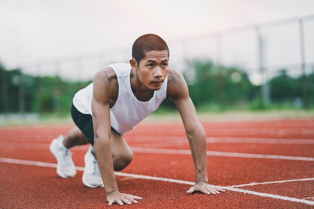 Atletas deportistas corredores con ropa deportiva blanca para estirar y calentar antes de practicar en una pista de atletismo en un estadio Concepto de deporte de corredor