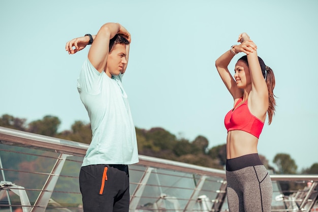 Foto atletas estirando las manos antes de entrenar en el puente de la ciudad