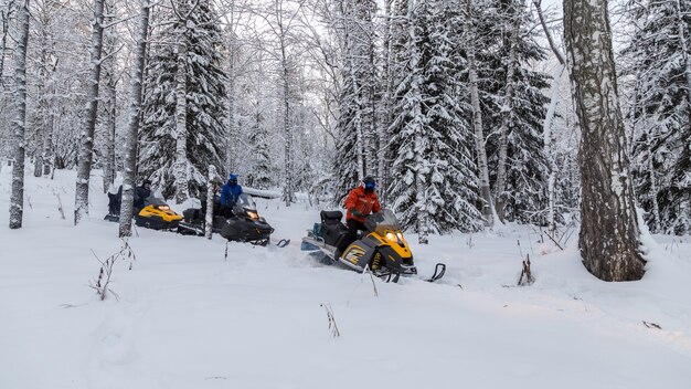 Atletas en una moto de nieve.