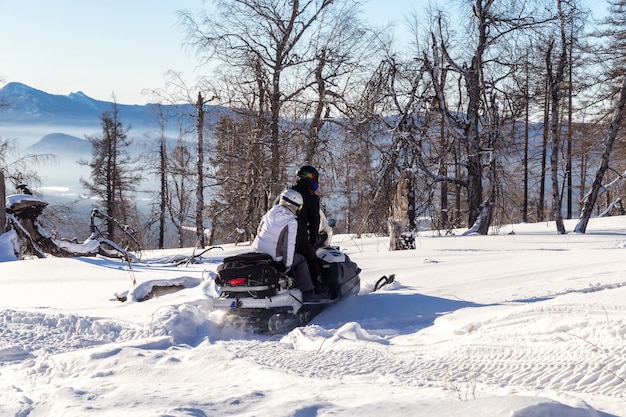 Atletas en una moto de nieve.