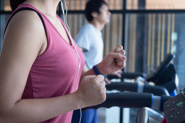 Atletas se exercitam na sala de ginástica Pessoas saudáveis correm em uma esteira na sala de ginástica para se exercitar