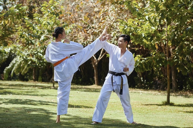 Atletas de taekwondo que luchan al aire libre