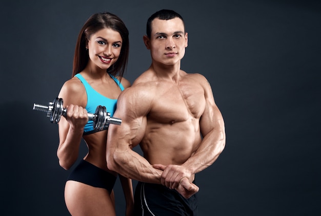 Foto atlético homem e mulher com um dumbells