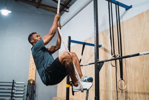 Atlético homem fazendo exercício de escalada.