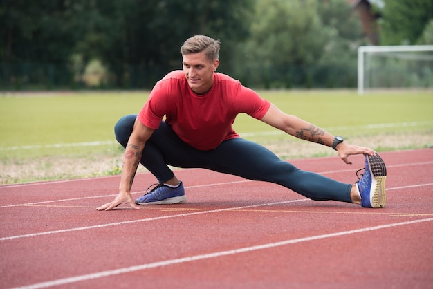 Atlético jovem alongamento antes de correr o exercício