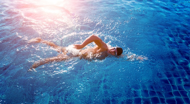 Foto atlético jovem nadando na piscina