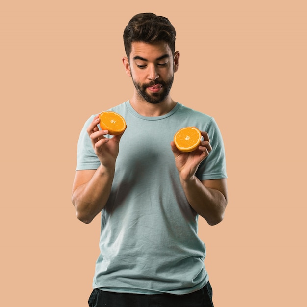 Foto atlético joven sosteniendo una naranja