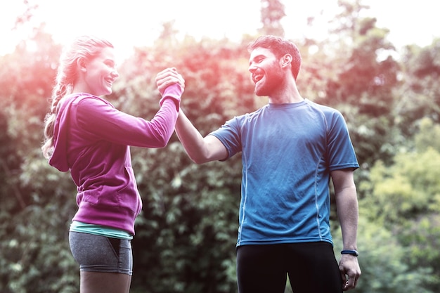 Atlético pareja cogidos de la mano en el bosque