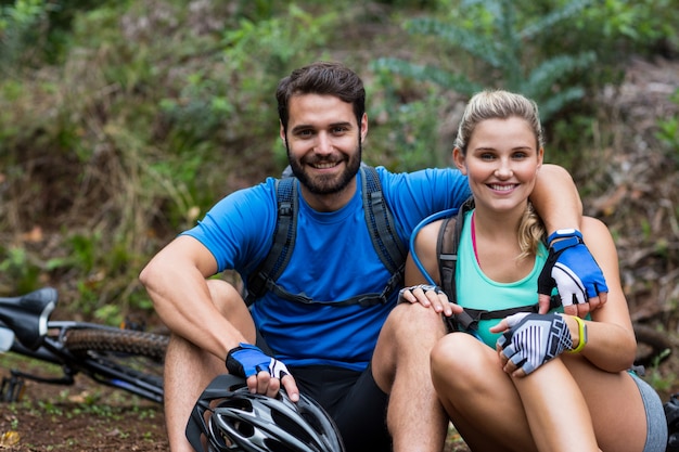 Atlético pareja relajante en bosque