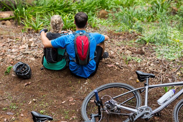 Atlético pareja relajante en bosque