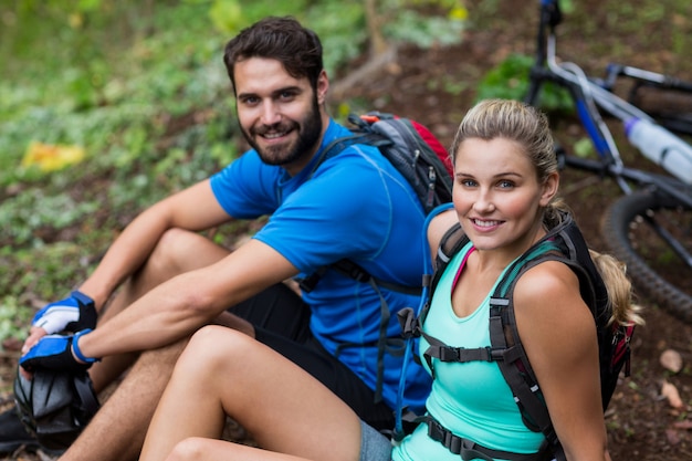 Atlético pareja relajante en bosque