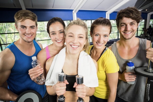 Atléticos hombres y mujeres posando en el gimnasio crossfit