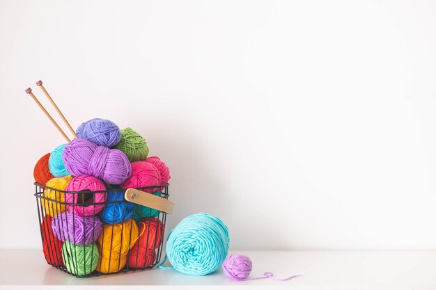 Atmosfera acogedora y hogareña Hobby femenino tejer y ganchetear hilo multicolor en una canasta Pieles y bolas Concepto de pasatiempo Espacio de copia