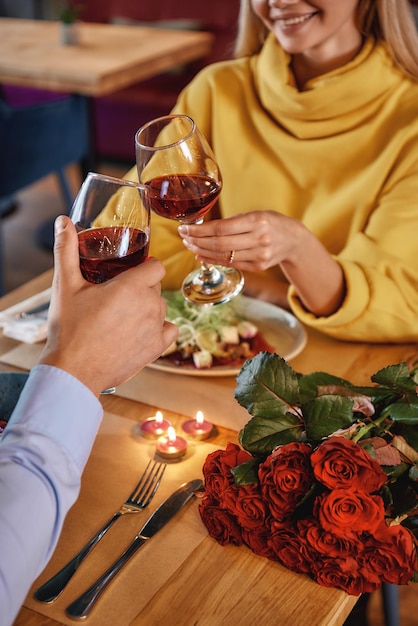 Foto atmosfera amorosa jovem casal romântico está comemorando aniversário em restaurante