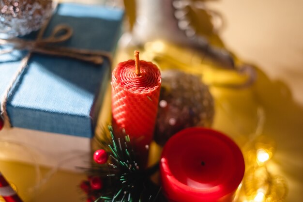 Atmósfera de año nuevo Vela de regalo de año nuevo y guirnalda de juguetes de Navidad sobre fondo amarillo