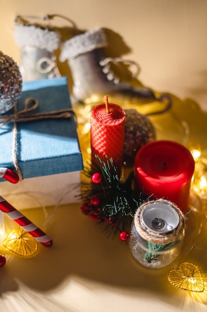 Atmosfera de ano novo Vela de presente de ano novo e guirlanda de brinquedos de Natal em fundo amarelo