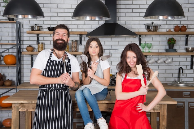 Atmósfera hogareña niña pequeña diviértete con mamá y papá madre padre e hijo cocinando tiempo de unión familiar familia feliz en la cocina el mejor equipo de la historia familia en la cocina preparando el desayuno juntos