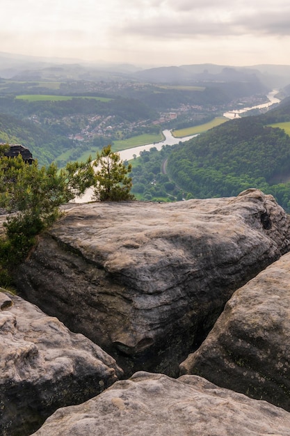 atmosfera matinal raios do sol nascente vista através das falésias de Bad Schandau na Suíça saxônica em uma manhã de névoa cedo a ponte Carolabrucke no rio Elba