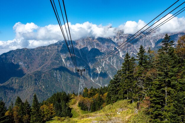 Foto la atmósfera de la principal atracción turística shin hotaka en los colores del otoño con un teleférico y teleférico que sirve a los turistas teleférico shinhotaka de los alpes japoneses y follaje de otoño