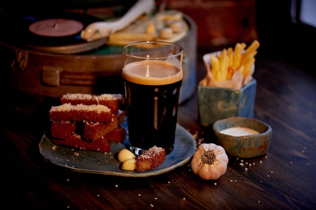 La atmósfera del viejo café El jugador con el disco un vaso de cerveza oscura pan de ajo y papas fritas Comida rápida