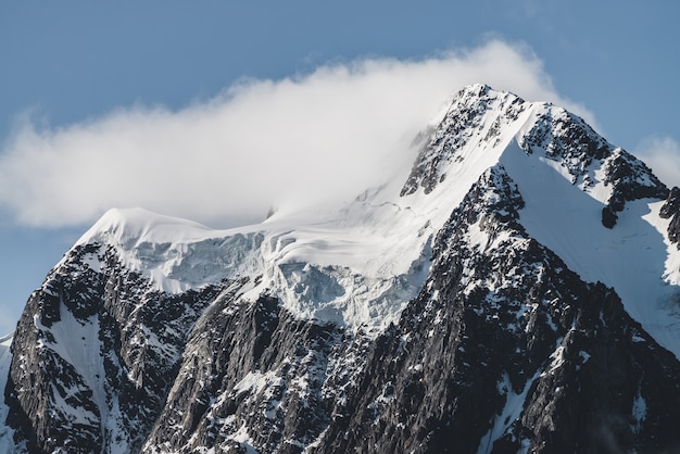 Atmosférico paisaje alpino minimalista con un enorme glaciar colgante en el pico nevado de la montaña.