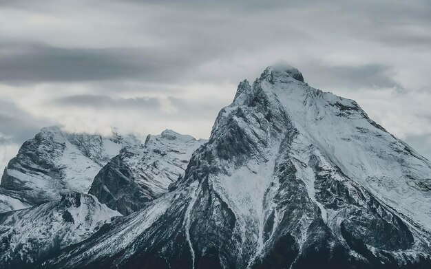 Atmosphärische Alpenlandschaft mit schneebedeckten Bergspitzen unter schneegrauem Himmel