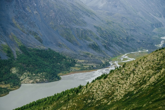 Atmosphärische alpine Landschaft mit wunderschönem Tal mit Bergsee und riesigem strukturiertem Hang