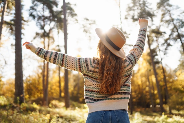 Atmosphärisches Lebensstil im Freien Porträt einer schönen Frau, die sich im Herbstwald amüsiert Warmer Herbst