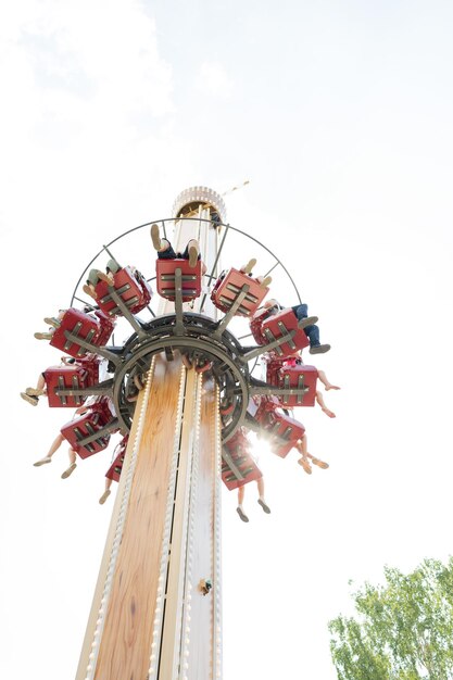 Una atracción en el parque, la gente monta en un carrusel, una vista desde abajo en un día soleado